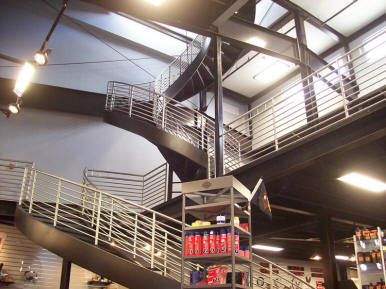 Sweeping custom curving architectural staircase designed and built for Syracuse, NY area Harley Davidson dealer